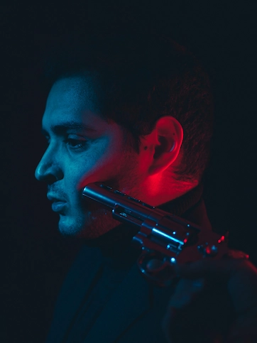 Imágen de actor siendo apuntado por una pistola